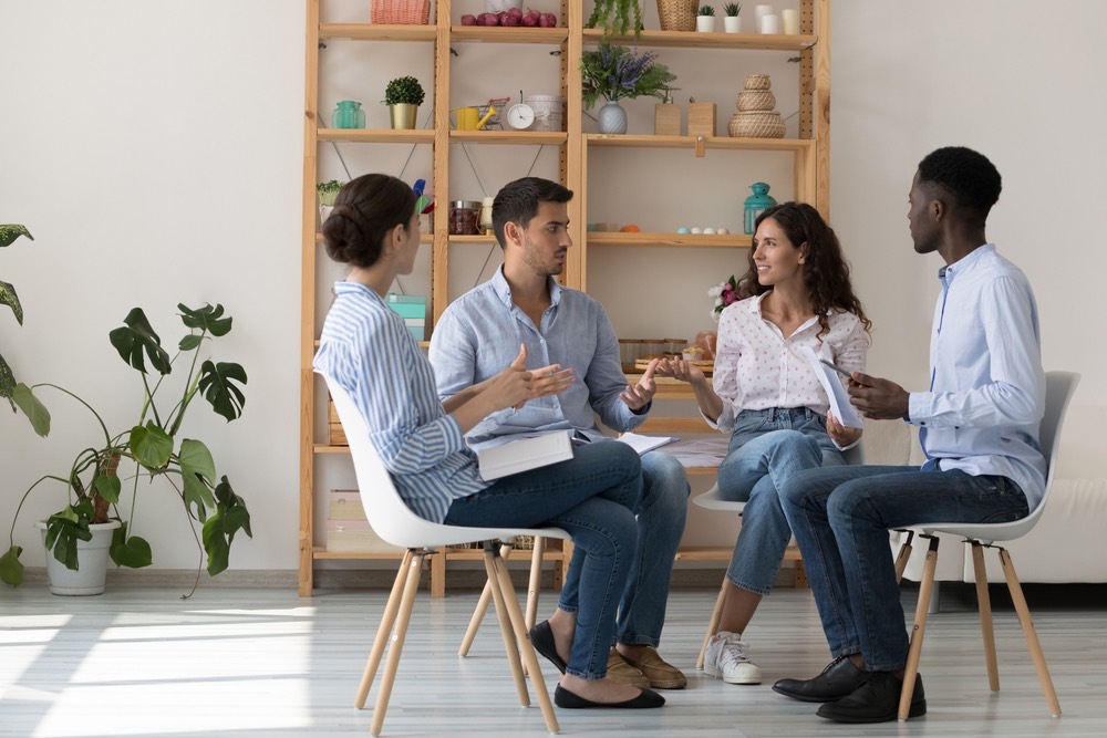 Four professionals seated in a circle having a group discussion